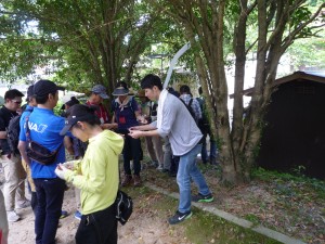 温泉の源泉横で学生が参加者にスタンプ押し